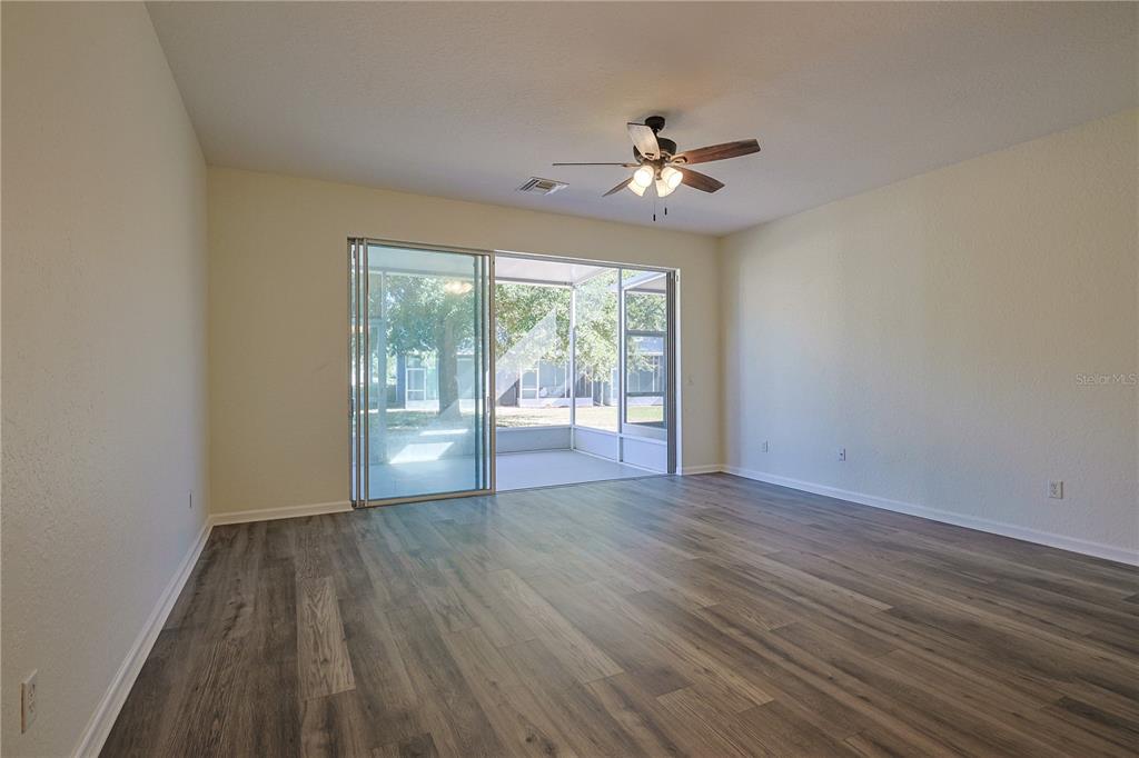 4116 Southwest 54th Circle Ocala, FL 34474 - Photo 10 of 36 a view of an empty room with wooden floor and a window