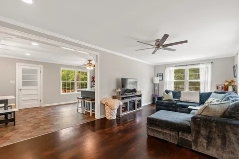a living room with furniture and a wooden floor