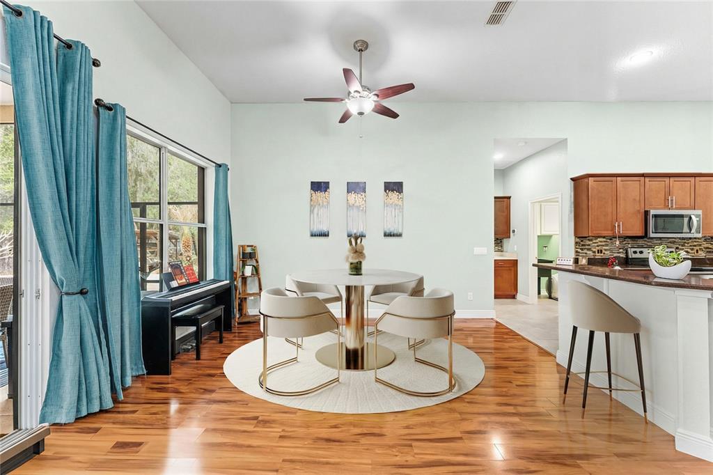 5130 Morning Dew Loop Oviedo, FL 32765 - Photo 11 of 38 a dining room with wooden floor a chandelier fan a glass table and chairs