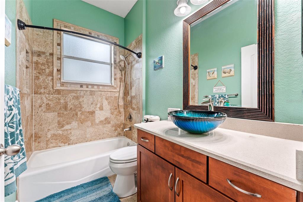 5130 Morning Dew Loop Oviedo, FL 32765 - Photo 25 of 38 a bathroom with a granite countertop sink a toilet a mirror and bathtub