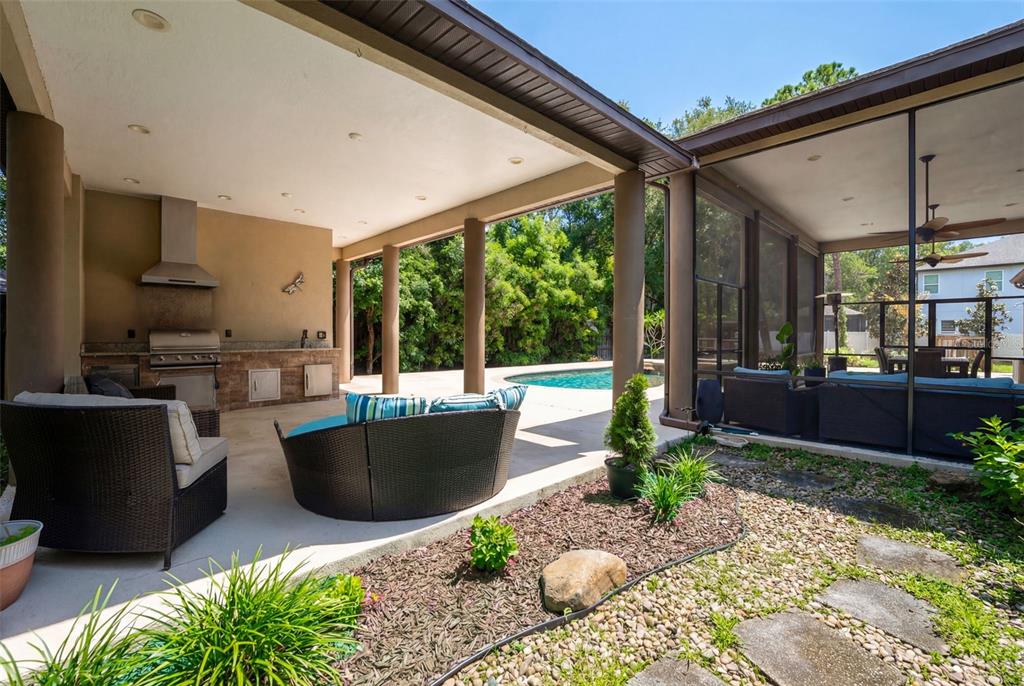 5130 Morning Dew Loop Oviedo, FL 32765 - Photo 3 of 38 a view of a patio with couches chairs potted plants and floor to ceiling window