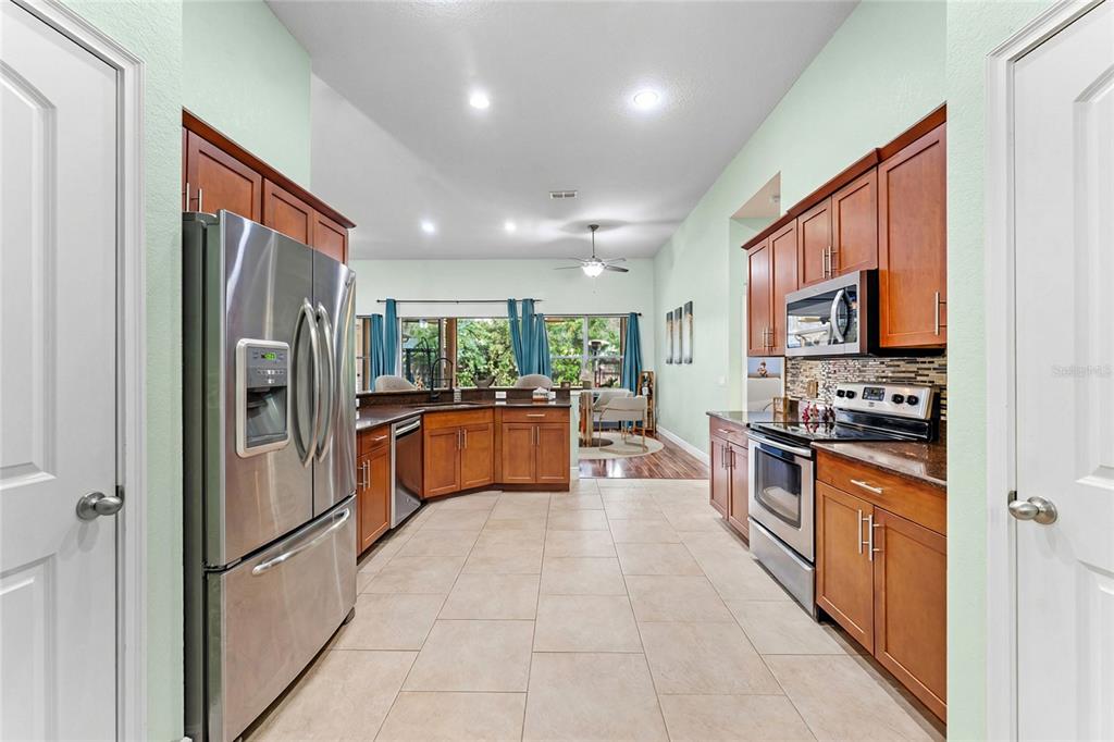 5130 Morning Dew Loop Oviedo, FL 32765 - Photo 8 of 38 a kitchen with stainless steel appliances granite countertop a refrigerator and a stove top oven