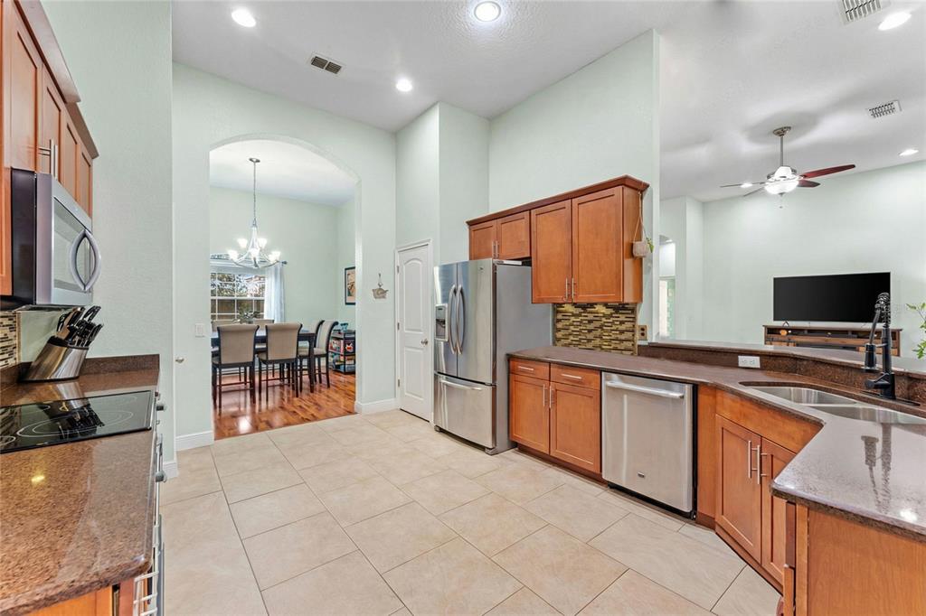 5130 Morning Dew Loop Oviedo, FL 32765 - Photo 9 of 38 a large kitchen with stainless steel appliances a sink and a refrigerator