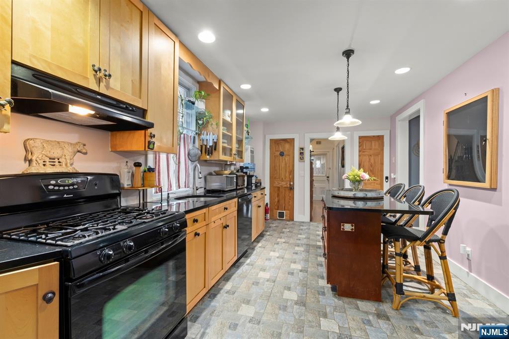 370 Undercliff Avenue Edgewater, NJ 07020 - Photo 16 of 35 a kitchen with stainless steel appliances granite countertop a stove a sink a refrigerator and chairs