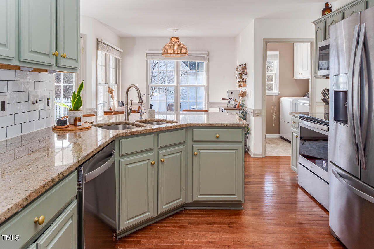 4552 Springbrook Drive Burlington, NC 27215 - Photo 12 of 57 a kitchen with stainless steel appliances a sink cabinets and wooden floor