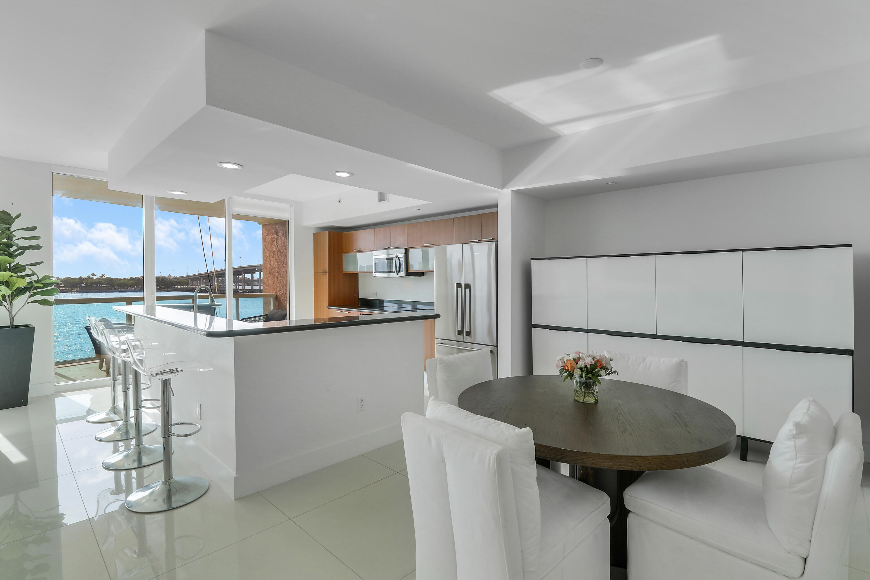 2640 Lake Shore Drive, Unit 307 Riviera Beach, FL 33404 - Photo 5 of 44 a kitchen with stainless steel appliances a sink a table and chairs