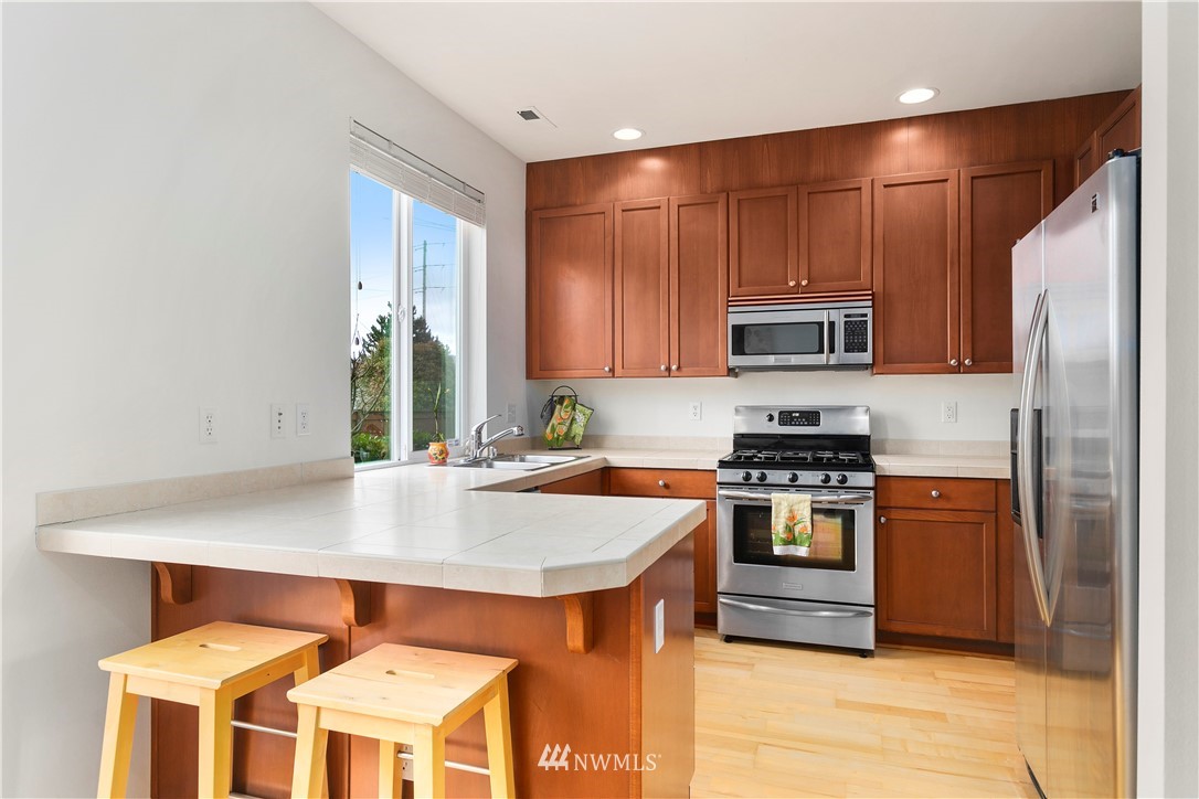 4024 Northeast 4th Place Renton, WA 98056 - Photo 11 of 29 a kitchen with stainless steel appliances a stove a sink a refrigerator and cabinets