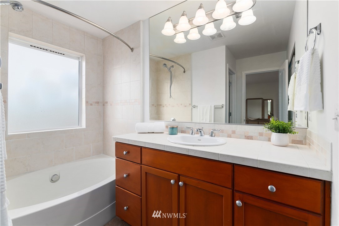 4024 Northeast 4th Place Renton, WA 98056 - Photo 18 of 29 a bathroom with a sink double vanity granite tub shower and a mirror