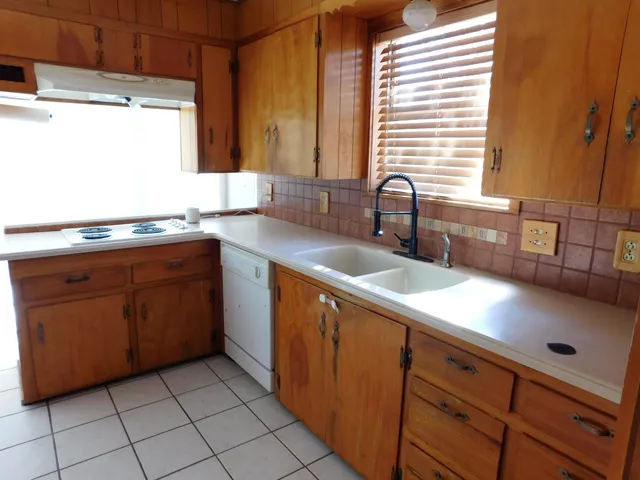 a kitchen with kitchen island granite countertop a sink and a stove