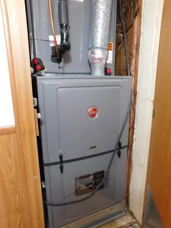 a room with water heater and white cabinet