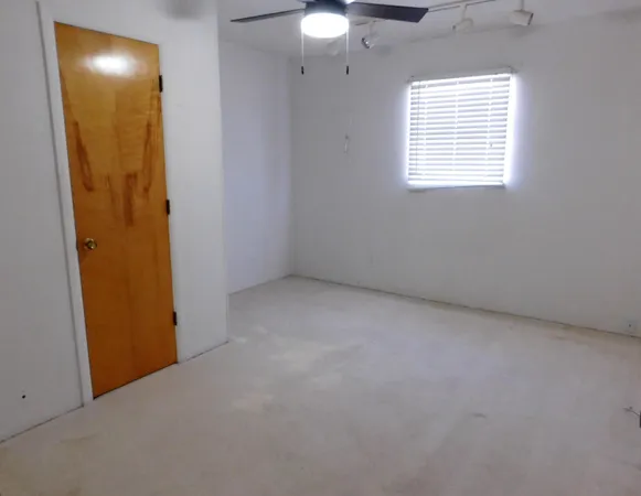 an empty room with windows and closet