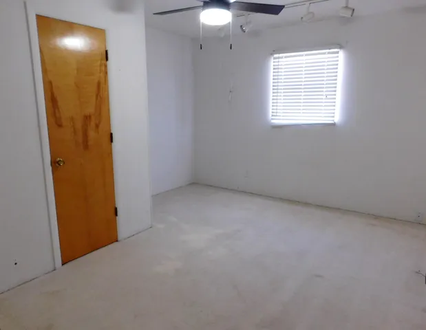 an empty room with windows and closet