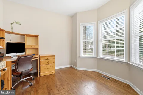 a view of a workspace with furniture and wooden floor
