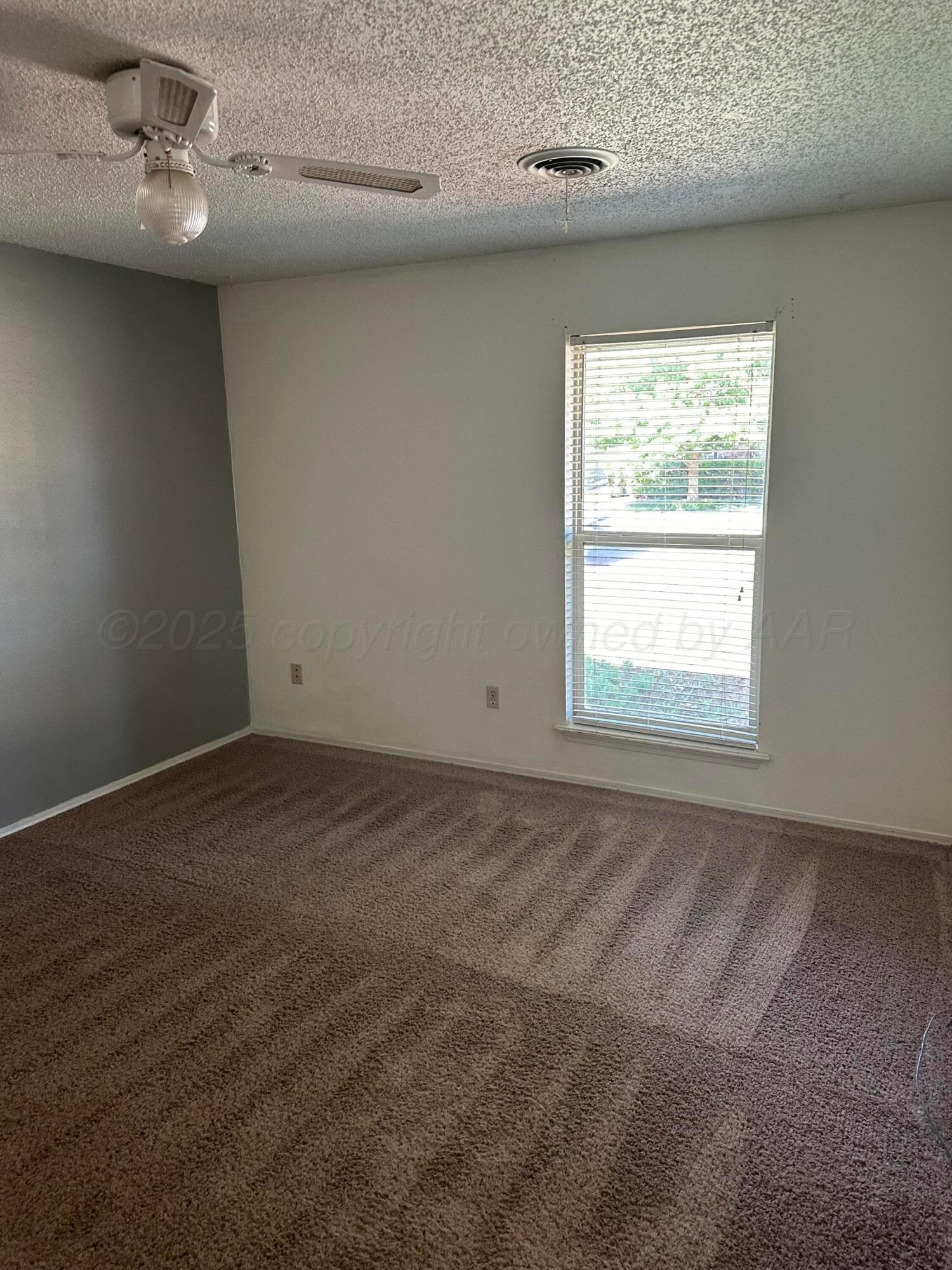 1003 Cimarron Trail Canyon, TX 79015 - Photo 12 of 16 an empty room with a ceiling fan and window