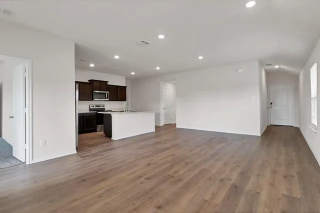 a view of kitchen with microwave stove refrigerator and cabinets