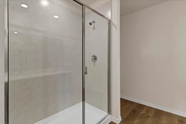 a bathroom with a shower and a glass door