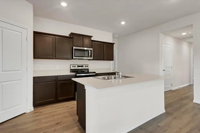 a kitchen with stainless steel appliances a stove microwave and refrigerator