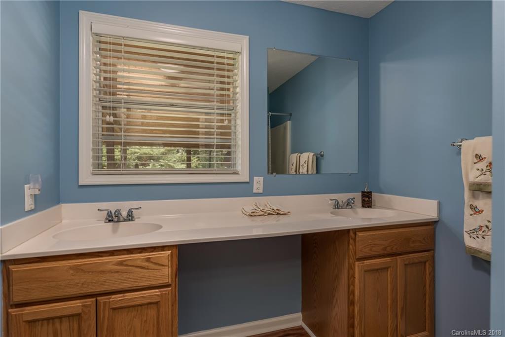 506 Jones Road Mill Spring, NC 28756 - Photo 14 of 32 a bath room with a sink vanity and a mirror
