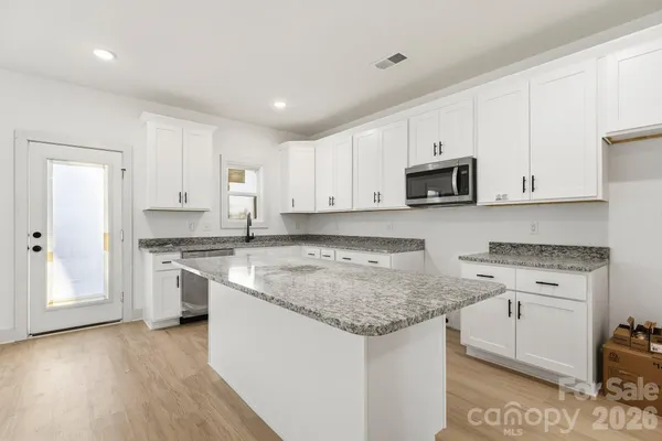 a kitchen with stainless steel appliances granite countertop a sink stove and microwave