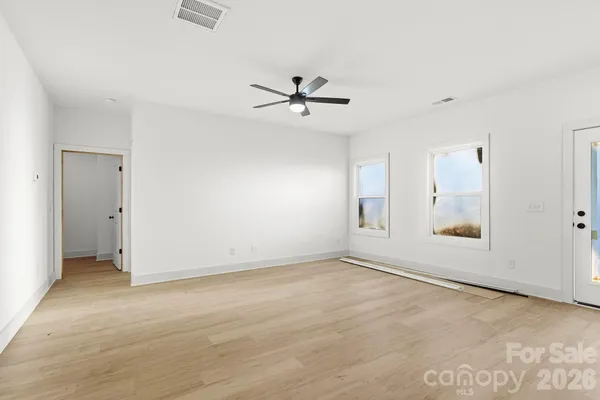 an empty room with fan and windows