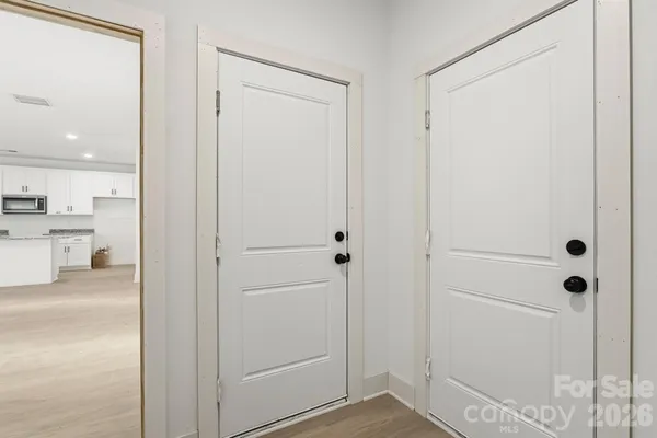 a view of a hallway with closet and a bathroom