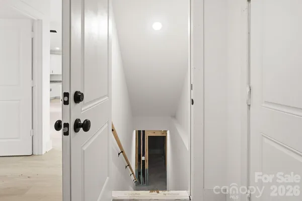 a view of a hallway with wooden floor and staircase