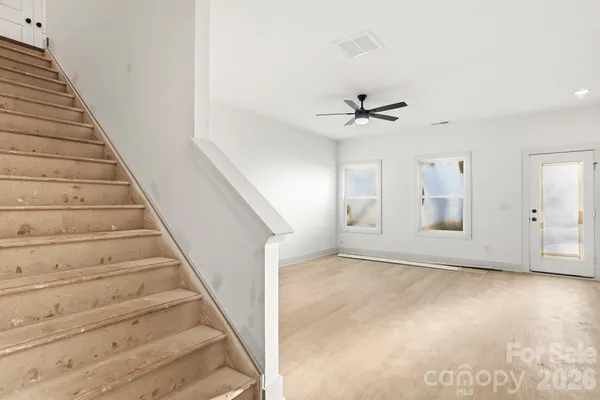 wooden floor in an empty room with a ceiling fan