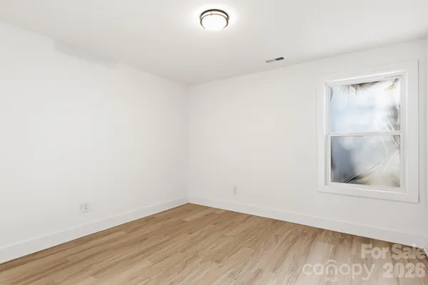 a view of a small space with wooden floor and a window