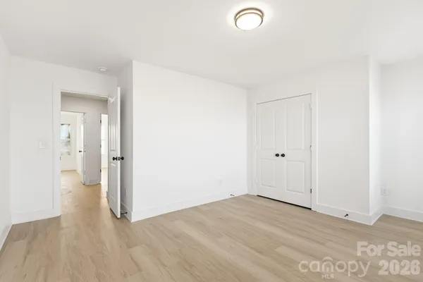 a view of a room with wooden floor and white walls