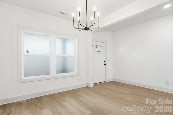 a view of empty room with wooden floor and ceiling fan