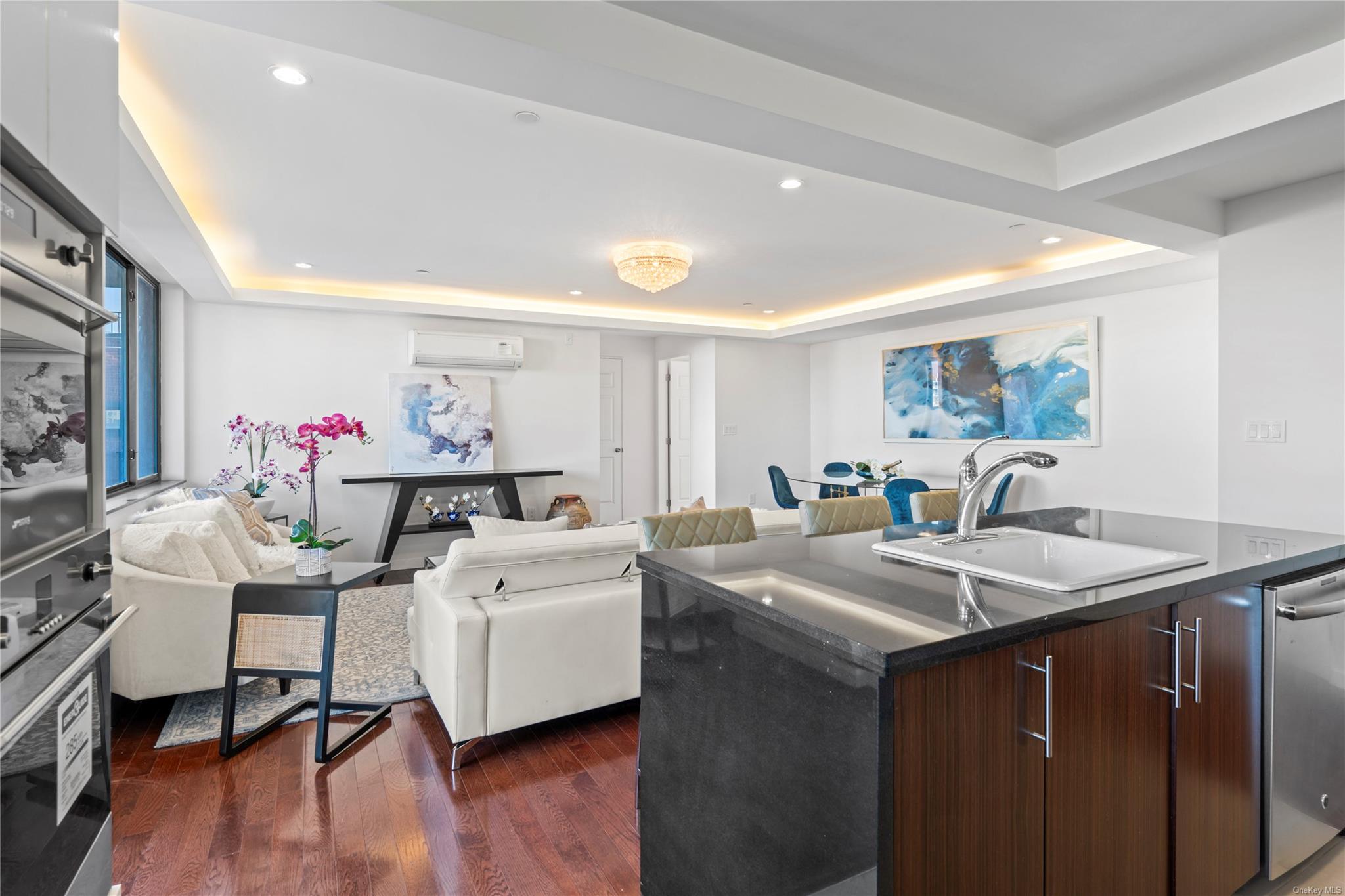 136-46 41st Avenue, Unit 6A Queens, NY 11355 - Photo 11 of 34 Kitchen featuring a tray ceiling, dark brown cabinetry, a center island, and stainless steel dishwasher