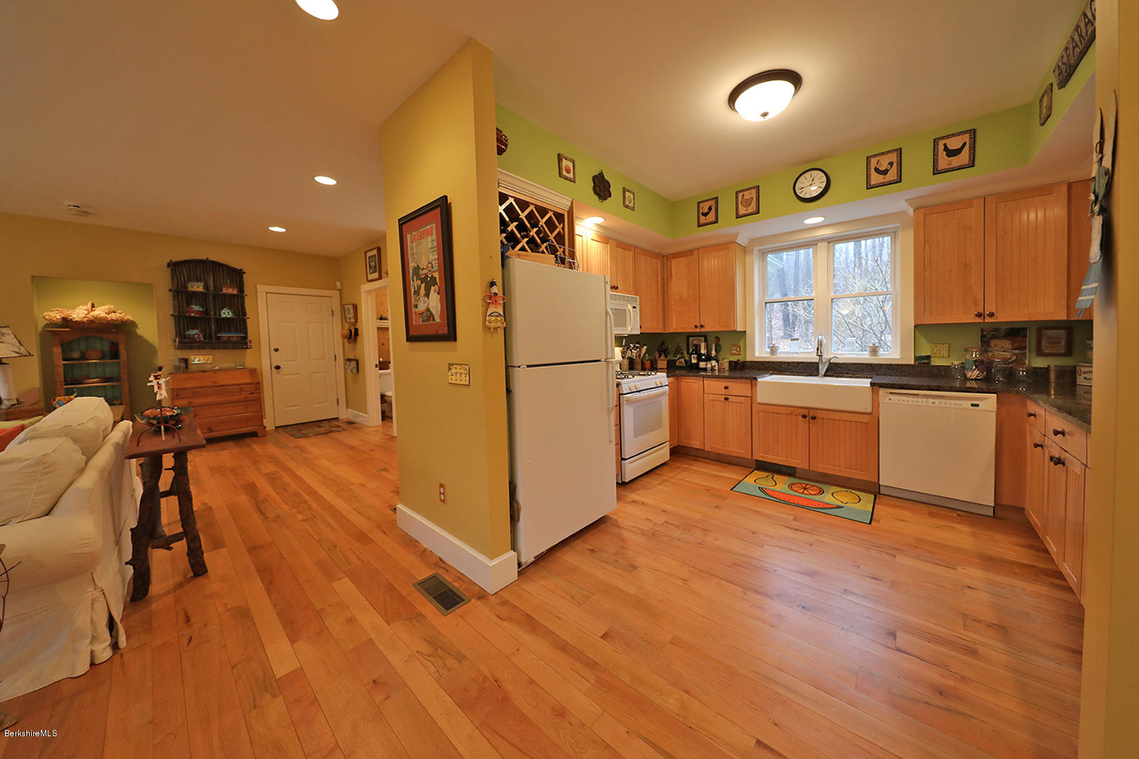 515 Ed Jones Road Otis, MA 01253 - Photo 8 of 21 a kitchen with granite countertop a refrigerator a stove a sink a dining table and chairs with wooden floor