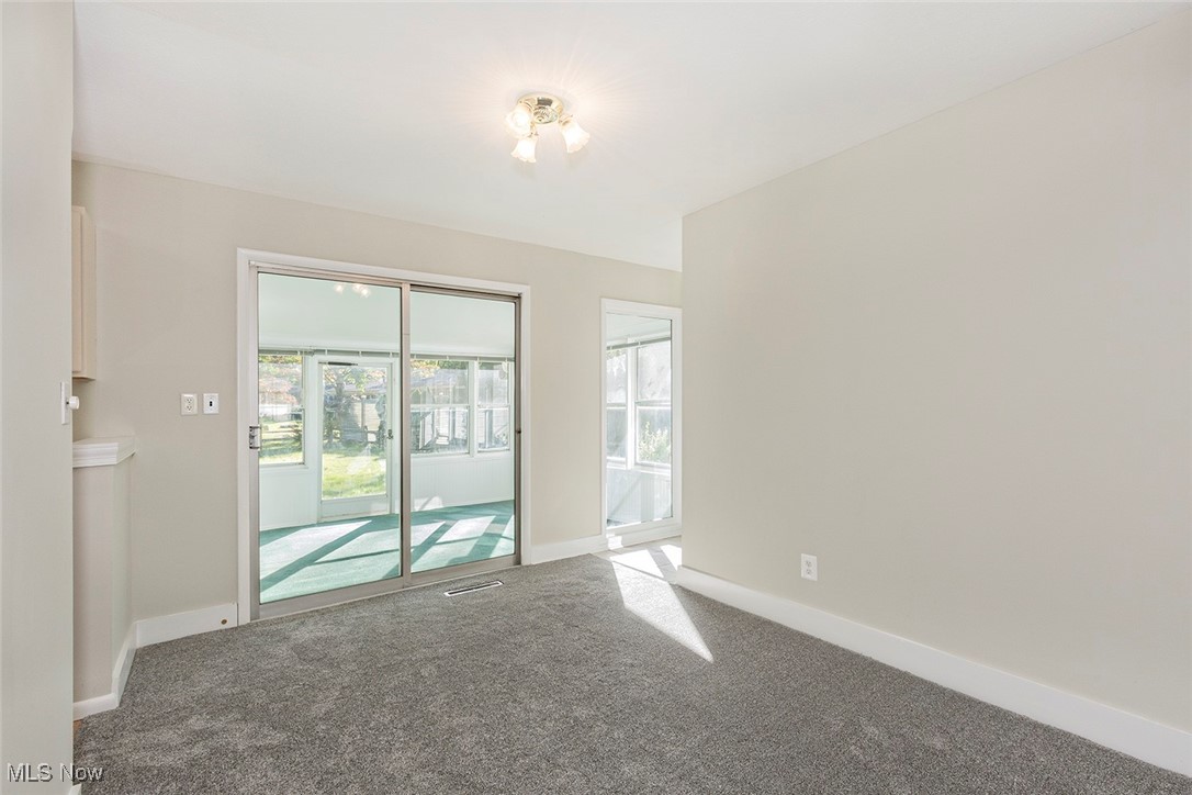 1691 Harwich Road Lyndhurst, OH 44124 - Photo 13 of 45 Dining room featuring carpet flooring and sliding doors to enclsed porch.