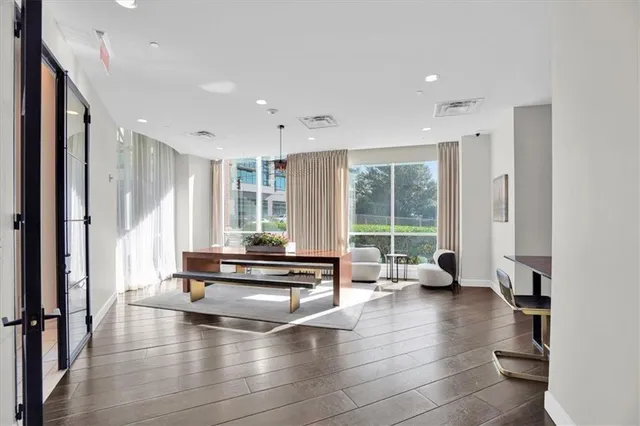 a living room with furniture large windows and wooden floor