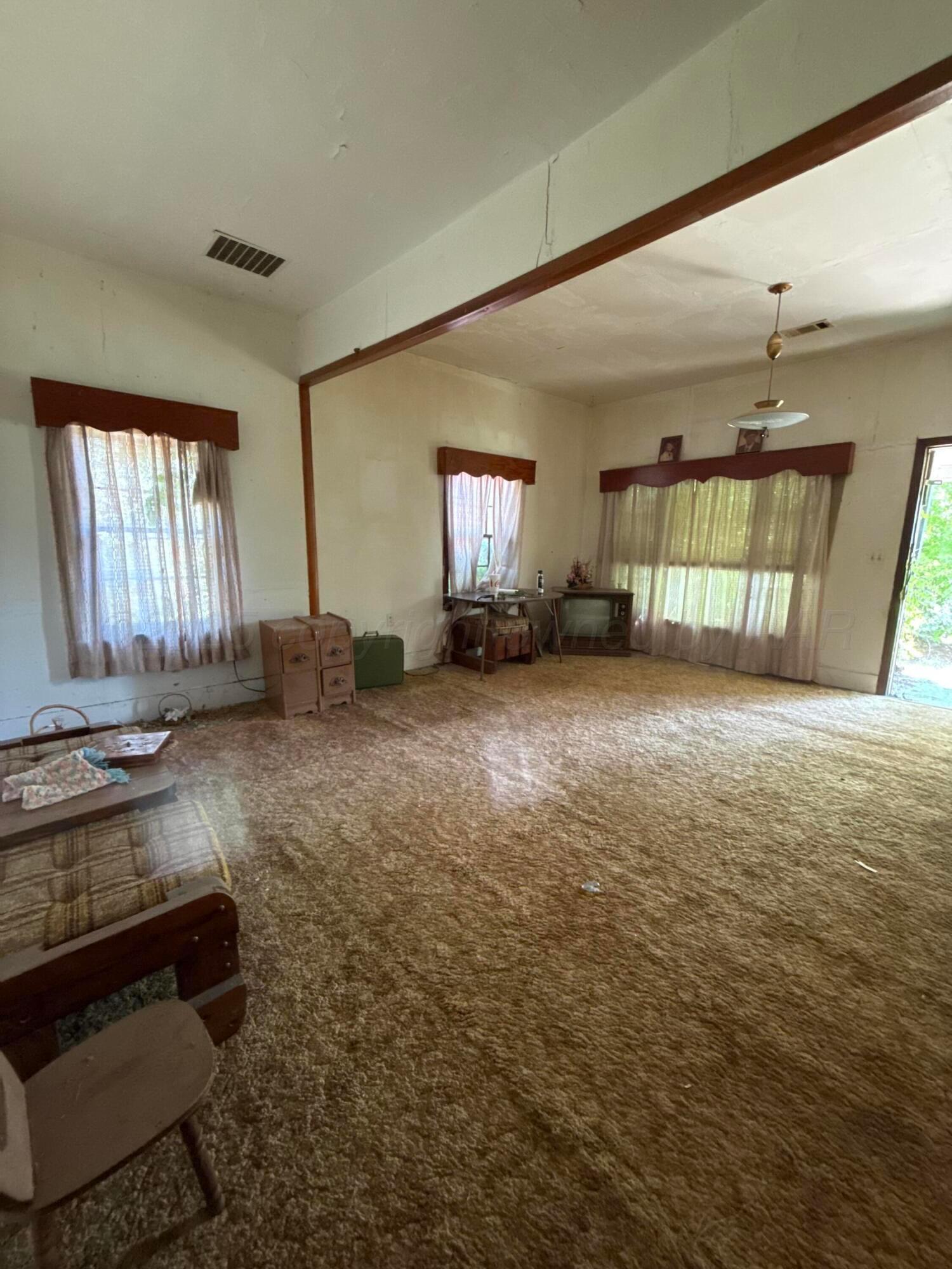 607 Clarendon Street McLean, TX 79057 - Photo 14 of 17 a view of a livingroom with wooden floor and a window