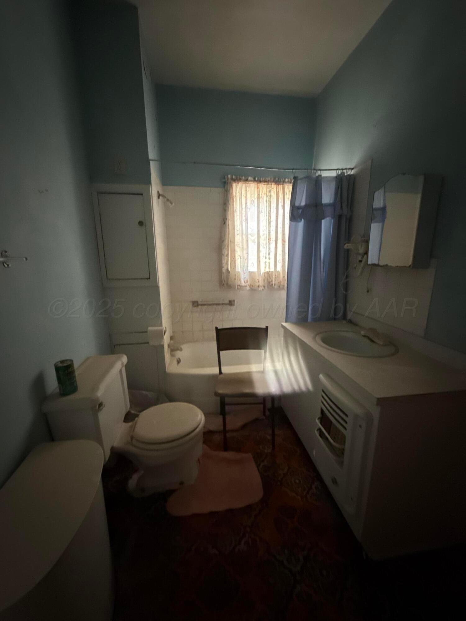 607 Clarendon Street McLean, TX 79057 - Photo 16 of 17 a bathroom with a sink toilet and window