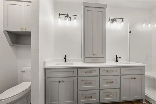 an empty room with wooden floor chandelier fan and windows