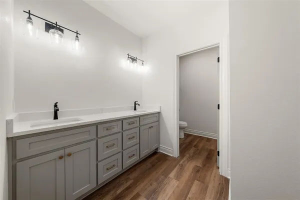 a bathroom with a granite countertop toilet and a sink