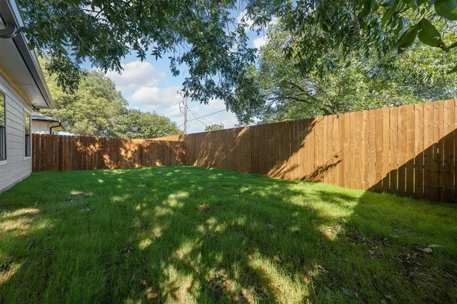 an empty room with a window and ceiling fan
