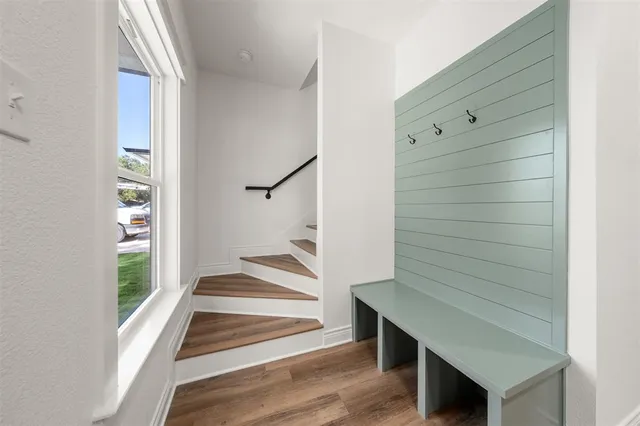 a view of kitchen and empty room with wooden floor