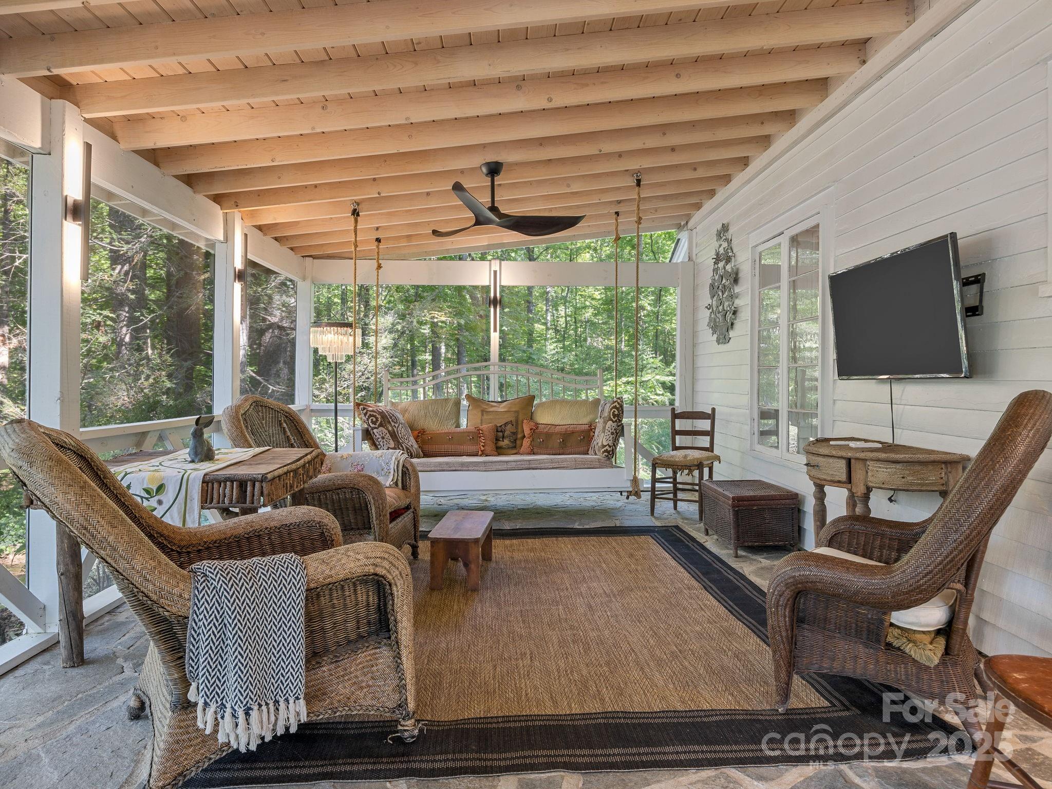 144 Miller Drive Tryon, NC 28782 - Photo 2 of 45 a living room with furniture a flat screen tv and a floor to ceiling window