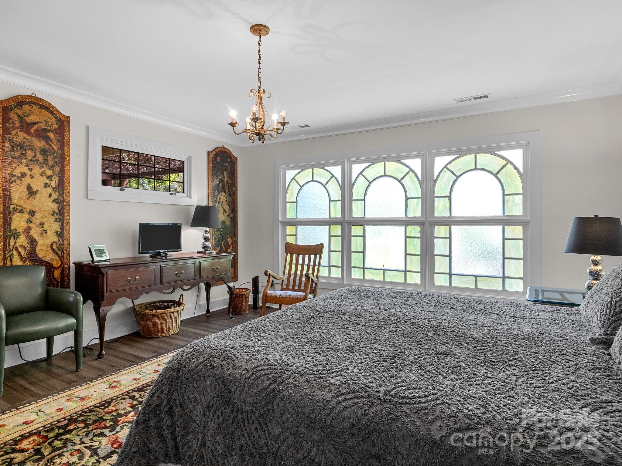 144 Miller Drive Tryon, NC 28782 - Photo 36 of 45 a spacious bedroom with a large bed and a chandelier