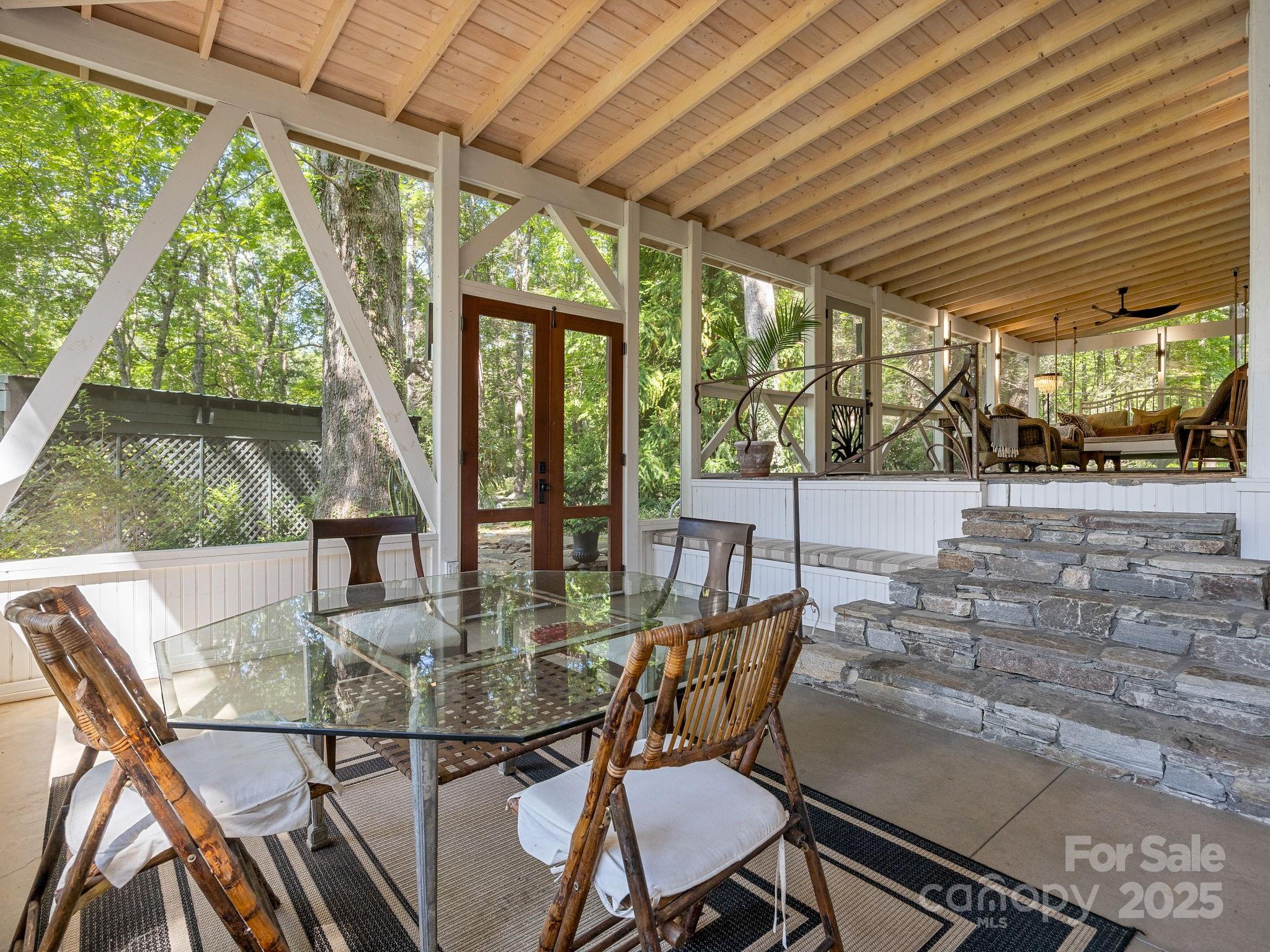 144 Miller Drive Tryon, NC 28782 - Photo 4 of 45 a view of a patio with table and chairs potted plants with floor to ceiling window
