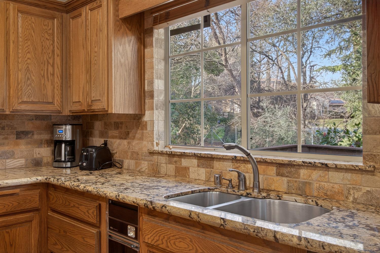 8681 Winding Way Fair Oaks, CA 95628 - Photo 23 of 87 a kitchen with granite countertop a sink a counter and cabinets