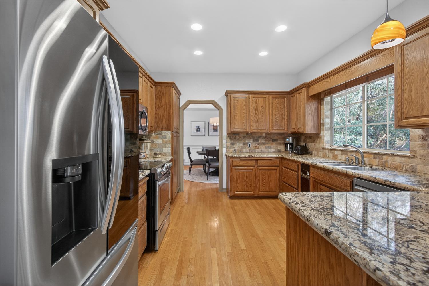 8681 Winding Way Fair Oaks, CA 95628 - Photo 29 of 87 a kitchen with stainless steel appliances granite countertop a refrigerator a sink dishwasher a stove and white countertops with wooden floor