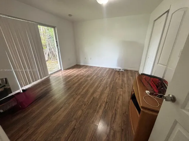 a view of a room with wooden floor and window