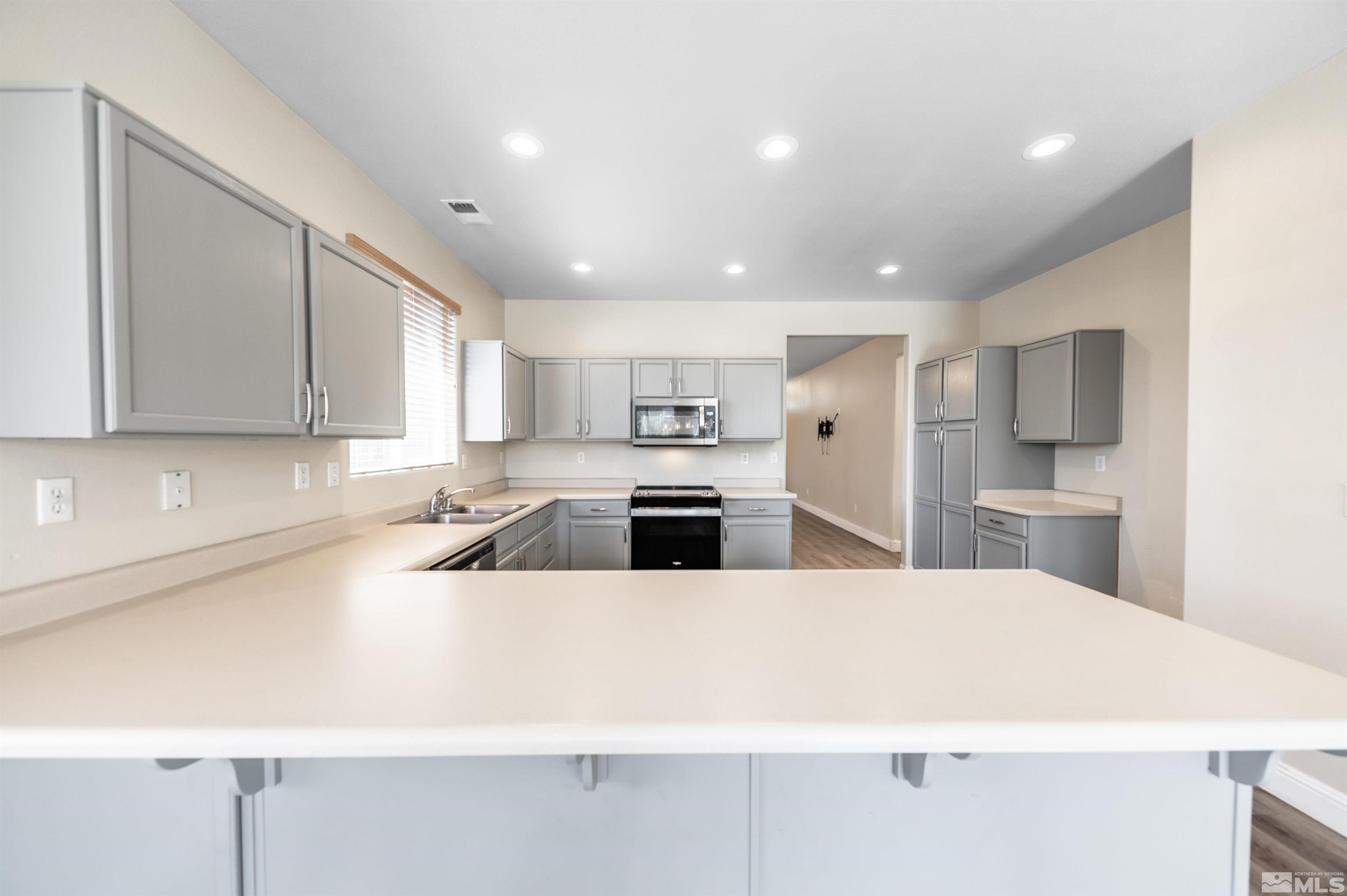 2260 Big Trail Circle Reno, NV 89521 - Photo 12 of 29 a large kitchen with kitchen island a sink a stove a refrigerator and cabinets