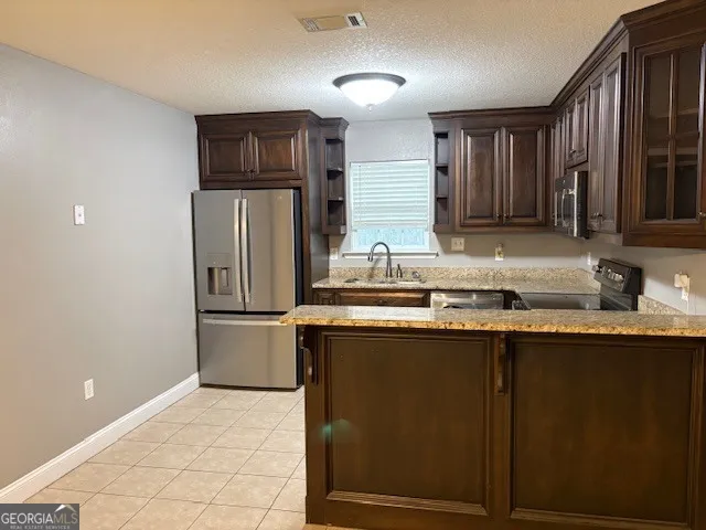a kitchen with stainless steel appliances granite countertop a refrigerator and a sink