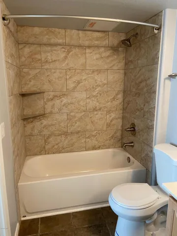 a bathroom with a toilet and a bath tub