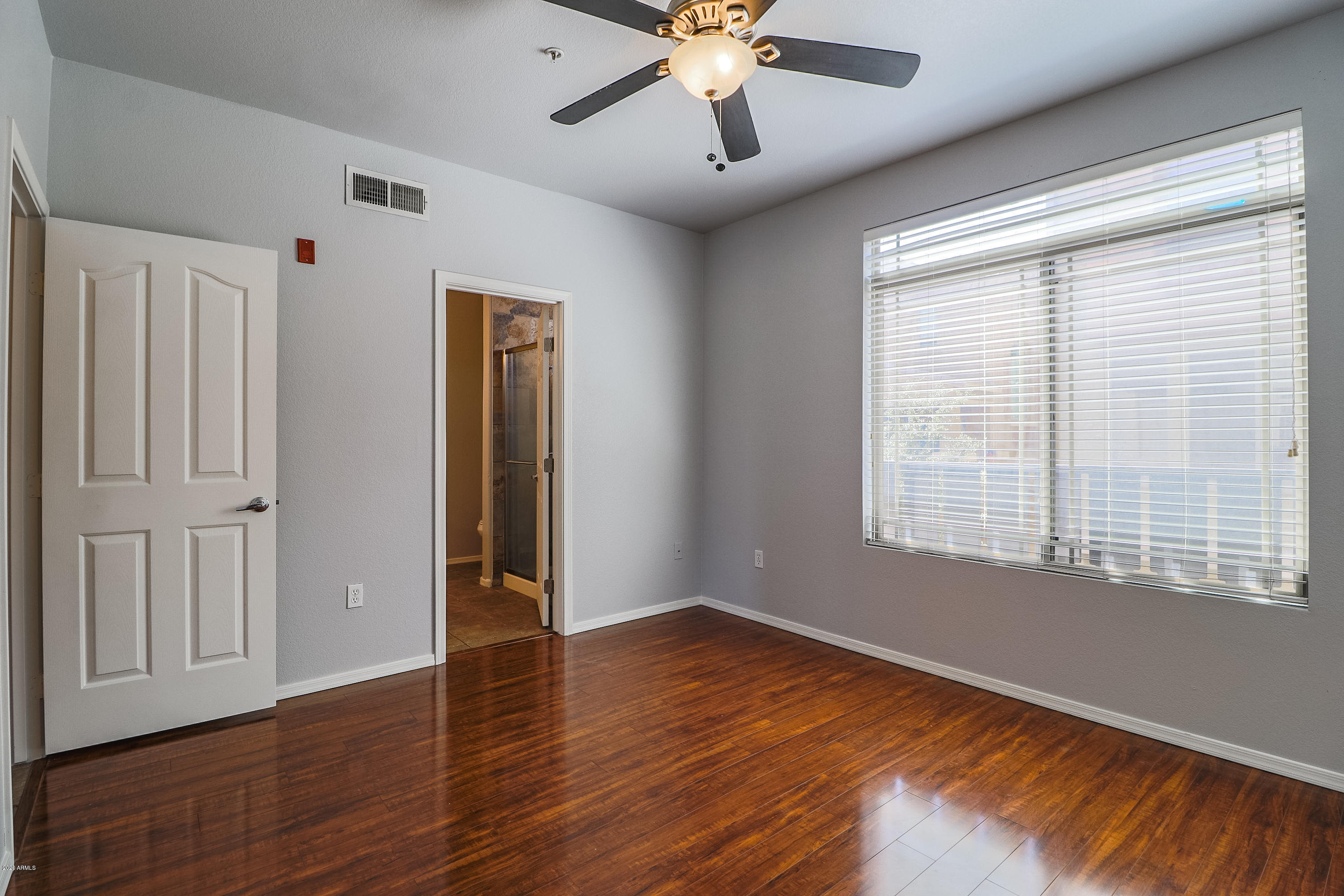 16825 North 14th Street, Unit 45 Phoenix, AZ 85022 - Photo 15 of 35 a view of an empty room with wooden floor and a window
